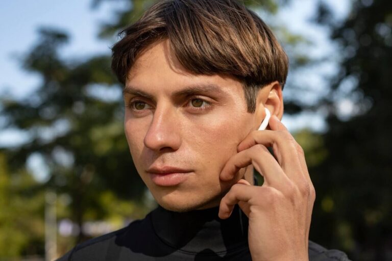 chico tocando auriculares inalámbricos